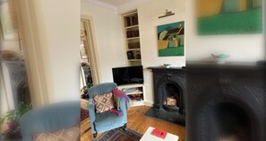 A living room with a fireplace, a television, and a bookshelf.