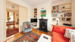 A living room with a fireplace, a bookshelf, a television, and a sofa.
