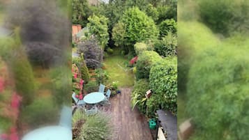 A garden with a wooden deck and a table.