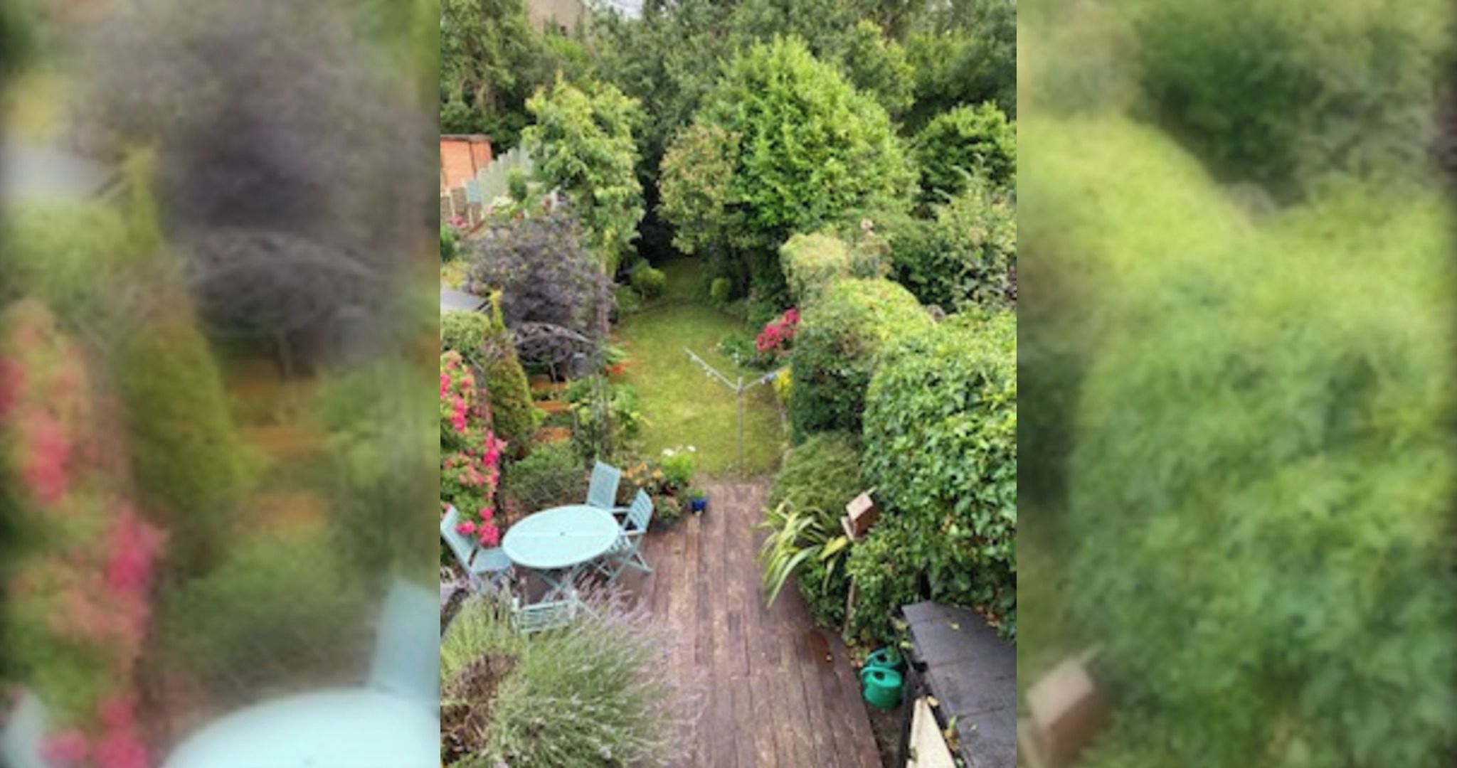 A garden with a wooden deck and a table.