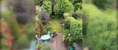 A garden with a wooden deck and a table.