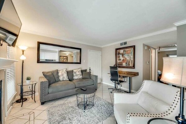 A living room with a sofa, a coffee table, a lamp, and a painting on the wall.