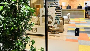 A hotel lobby with a seating area, a reception desk, and a display of hotel amenities. - Hotel 10 Sorriso (Sorriso)