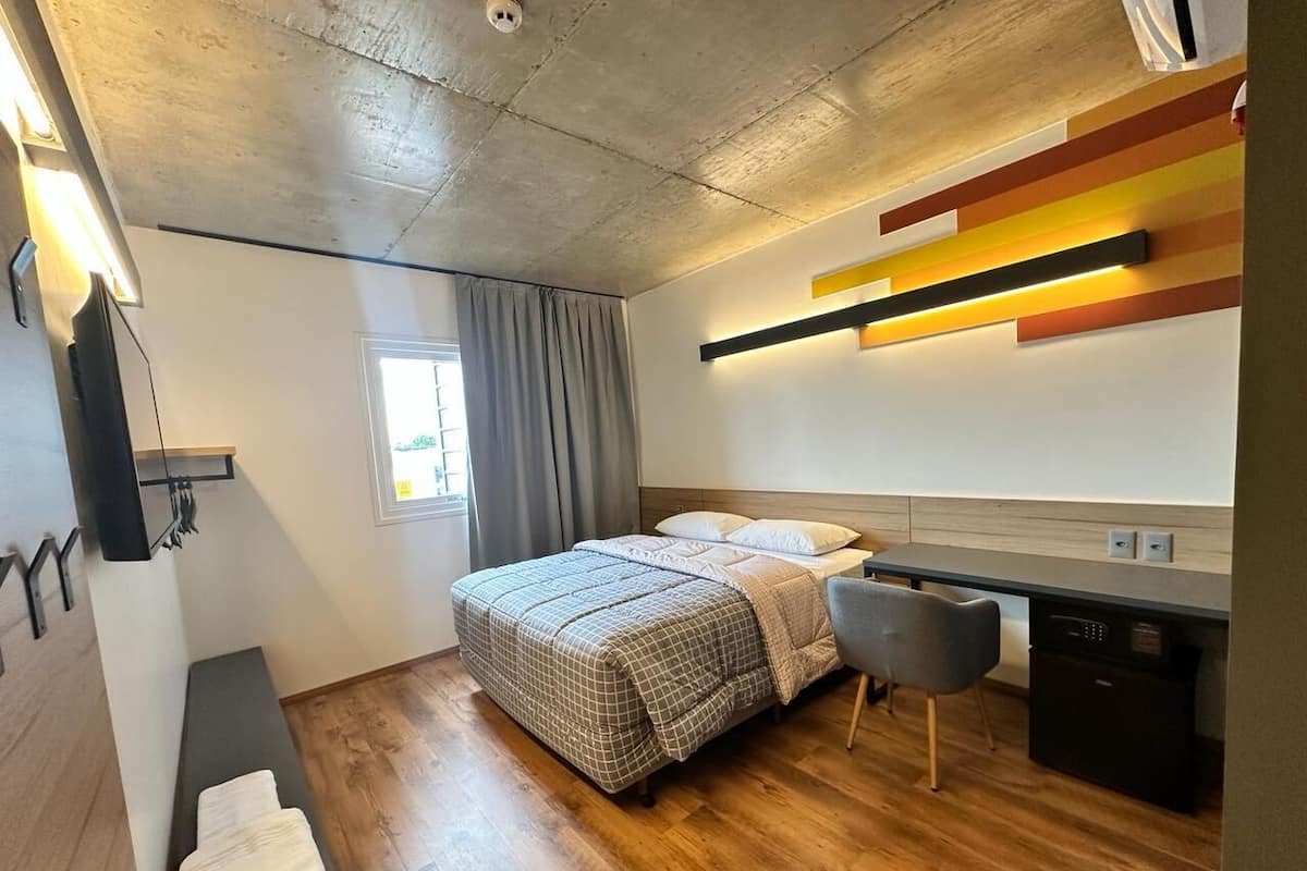 Un dormitorio moderno con cama, mesita de noche y zona de escritorio.