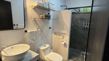 Een moderne badkamer met een grote spiegel, twee wastafels, een toilet en een douche.