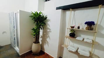 Chuveiro, toalhas de banho, sabonete, papel higiênico