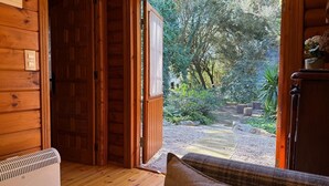 A wooden interior with a door leading to a garden. - Cabaña de Ensueño en el Bosque y Junto al Mar. Ideal Pareja ,dos Niños y Mascota (Miengo)