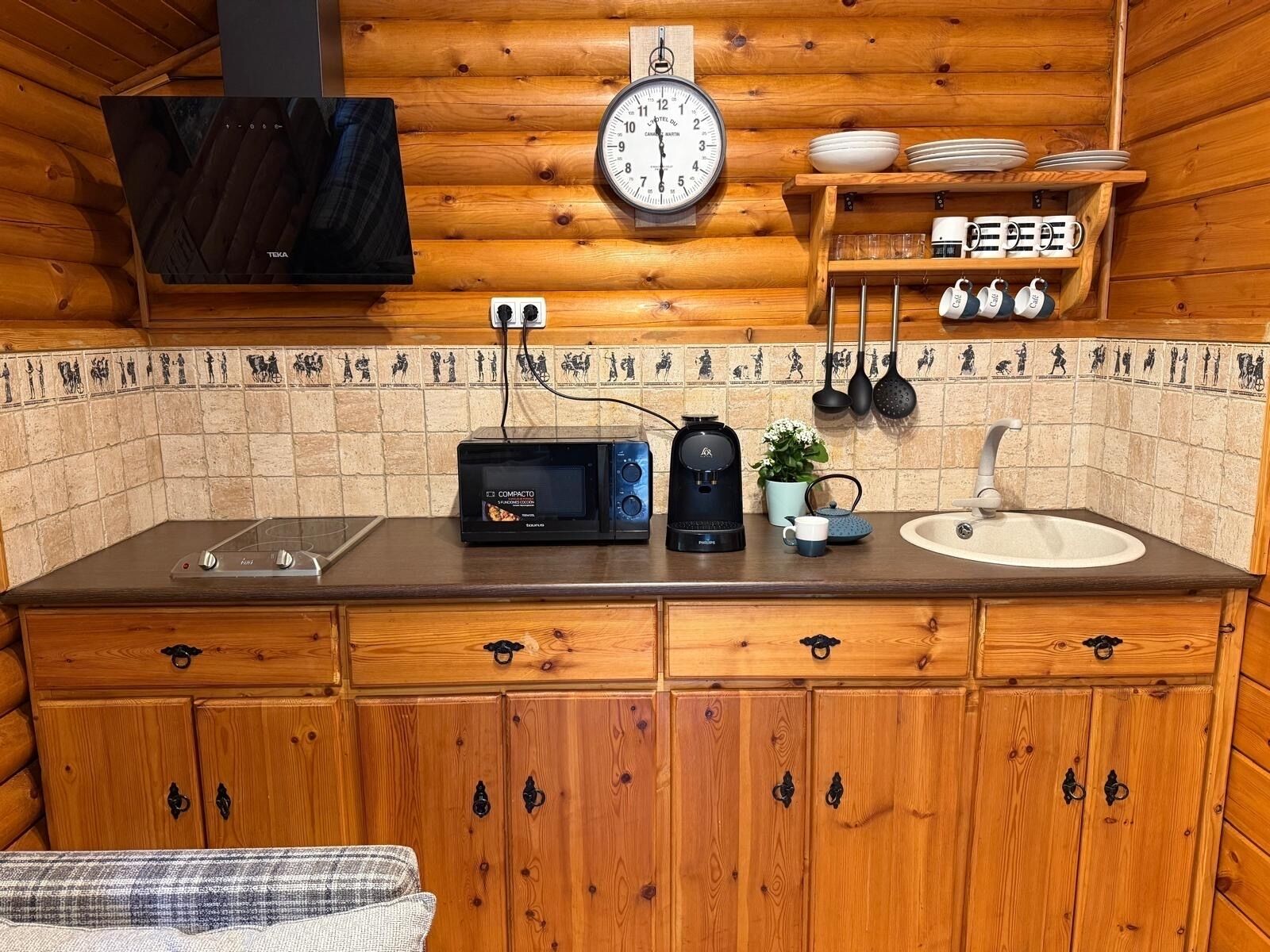 A compact kitchenette with a microwave, coffee maker, and sink.