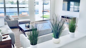 Un salon moderne avec un canapé, une table basse et des plantes en pot.