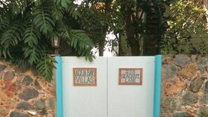 A gated entrance with signs reading "AQUA BAY VILLAS" and "238 SEAGRAPE LANE".