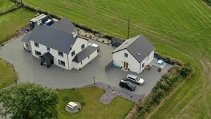 Une grande maison à deux étages avec une allée et un petit espace piscine.