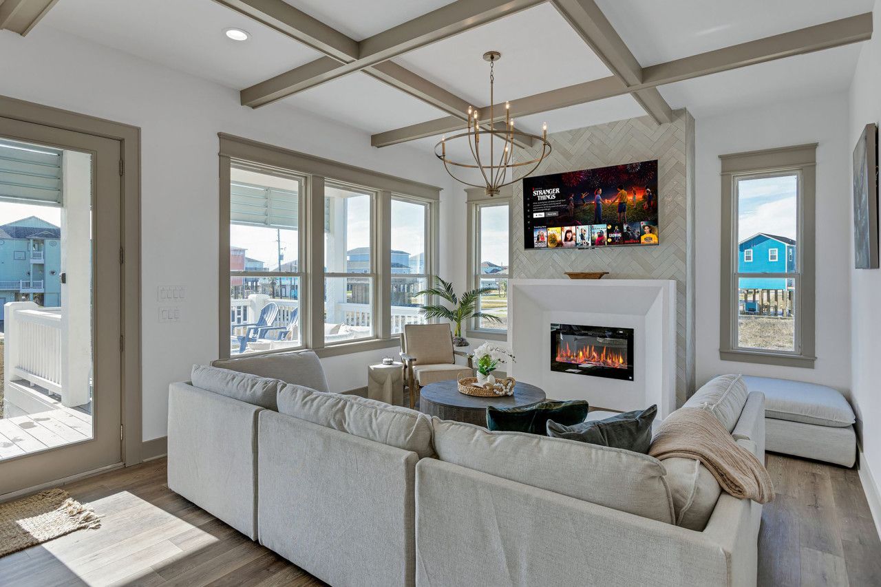 A modern living room with a fireplace, large windows, and a view of the city.