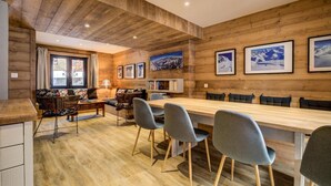 A cozy wooden interior with a dining area, a sofa, and a bookshelf. - Chalet, 200m from ski slopes, Ground floor, balcony, tv, ski locker, 150m², La Plagne (Aime)