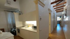 A modern kitchen with white cabinetry, a built-in microwave, and a sink. - LA Grande Bellezza (Venezia)