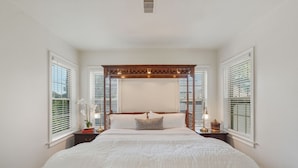 A bedroom with a four-poster bed, white bedding, and two bedside tables with lamps. - The King`s Castle II (Houston)