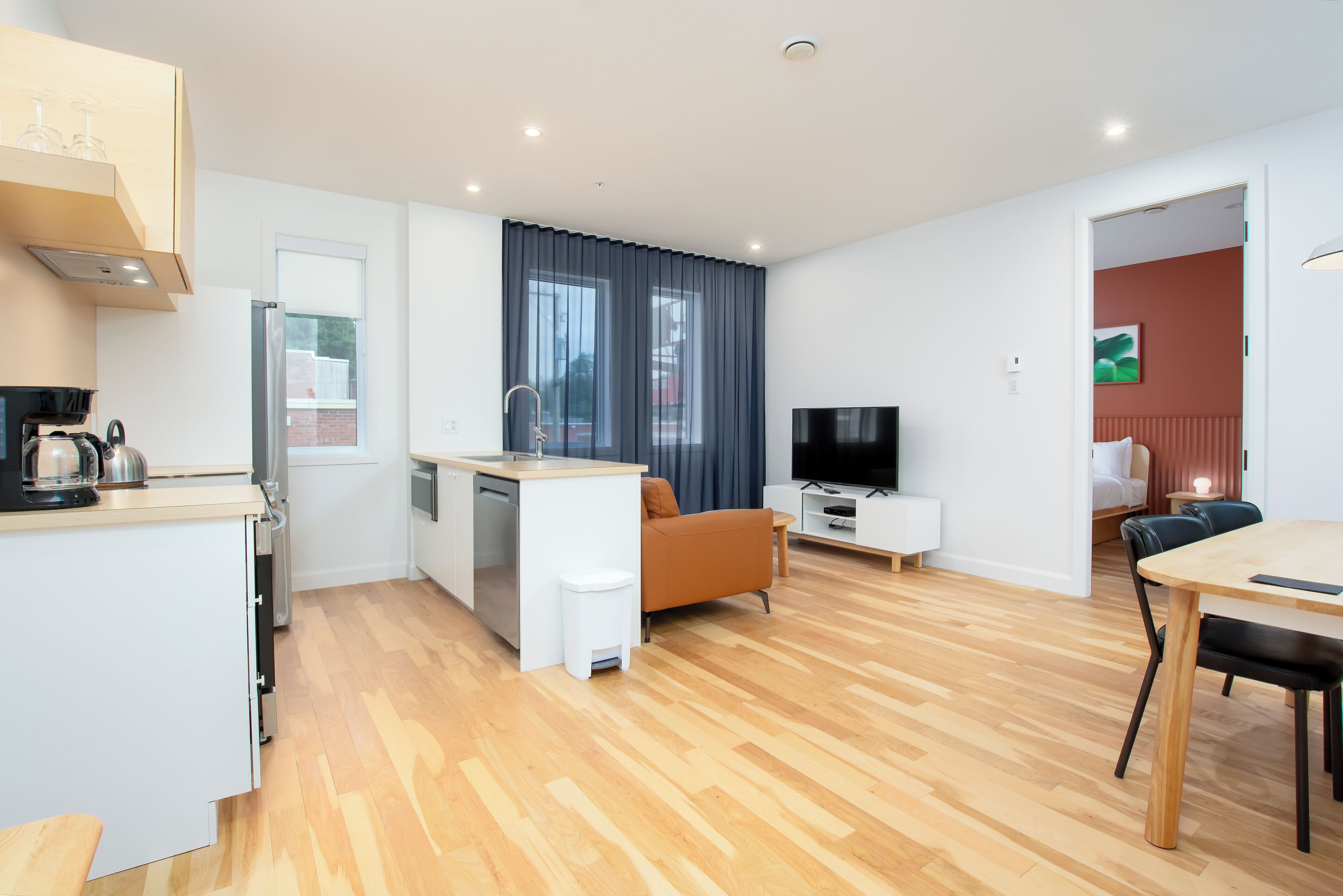 Eine moderne Wohnung mit Küche, Essbereich und Wohnzimmer.