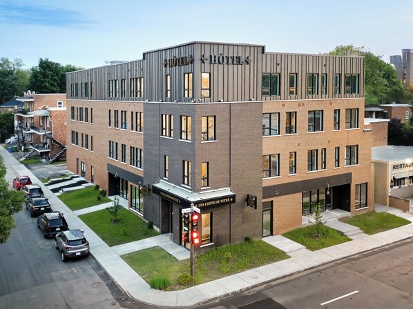 A modern hotel with a flat roof, multiple windows, and a sign indicating a restaurant on the ground floor. - Les Lofts de Vitré - Par Les Lofts Vieux-Québec (Québec City)
