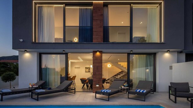 A modern two-story house with a swimming pool, outdoor seating, and a staircase leading to the upper floor. - Luxury Villa Lux with Heated Pool (Kaštel Kambelovac)