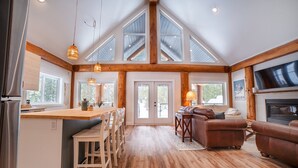 A spacious kitchen with a central island, wooden beams, and large windows. - Escape to a cabin in the woods (Sunshine Valley, BC, Canada) (Sunshine Valley)
