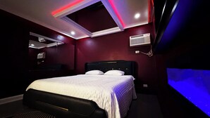 A modern bedroom with a bed, built-in air conditioning, and a ceiling light fixture. - Stone Creek Inn (Worth)