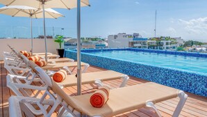 Zona de piscina al terrat amb gandules i ombrelles.
