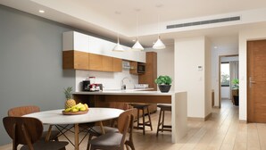 A modern kitchen with wooden cabinets, a central island, and pendant lighting. - Increible One bedroom Suite totalmente equipada (Playa del Carmen)