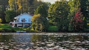 A house by a lake with lily pads on the water. - Hôtel à la maison - Chalet Lola (St-Tite)
