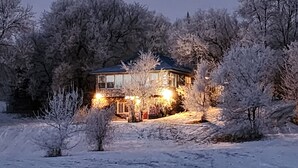 Una casa circondata da alberi innevati.