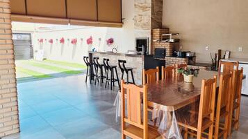 Enjoy al fresco dining in a serene outdoor setting surrounded by lush greenery and a cozy pergola.