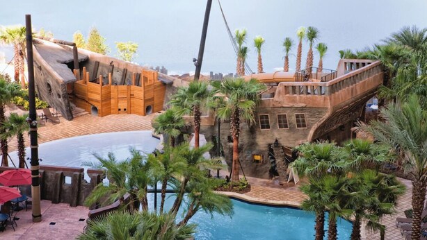 A pool area with a wooden ship structure, palm trees, and a stone building. - 3Bed/2Bath Condo in Gorgeous Orlando Resort Near Disney!! (Lake Buena Vista)