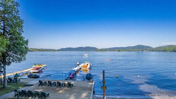 A lakeside dock with boats, a pier, and a row of chairs. - Enjoy a Relaxing Couples Getaway and Lakeside View at Stievater's Lakeside Cottages! (Inlet)