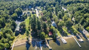 An aerial view of a lakeside property with multiple buildings, docks, and boats. - Enjoy a Relaxing Couples Getaway and Lakeside View at Stievater's Lakeside Cottages! (Inlet)