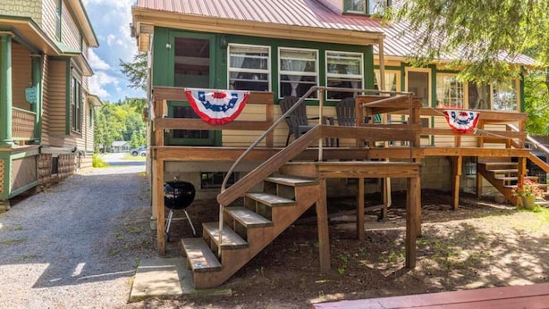 Eine Holztreppe führt zu einer Veranda mit einer Flagge.