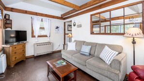 Una sala de estar acogedora con sofá, mesa de centro, televisor y chimenea.