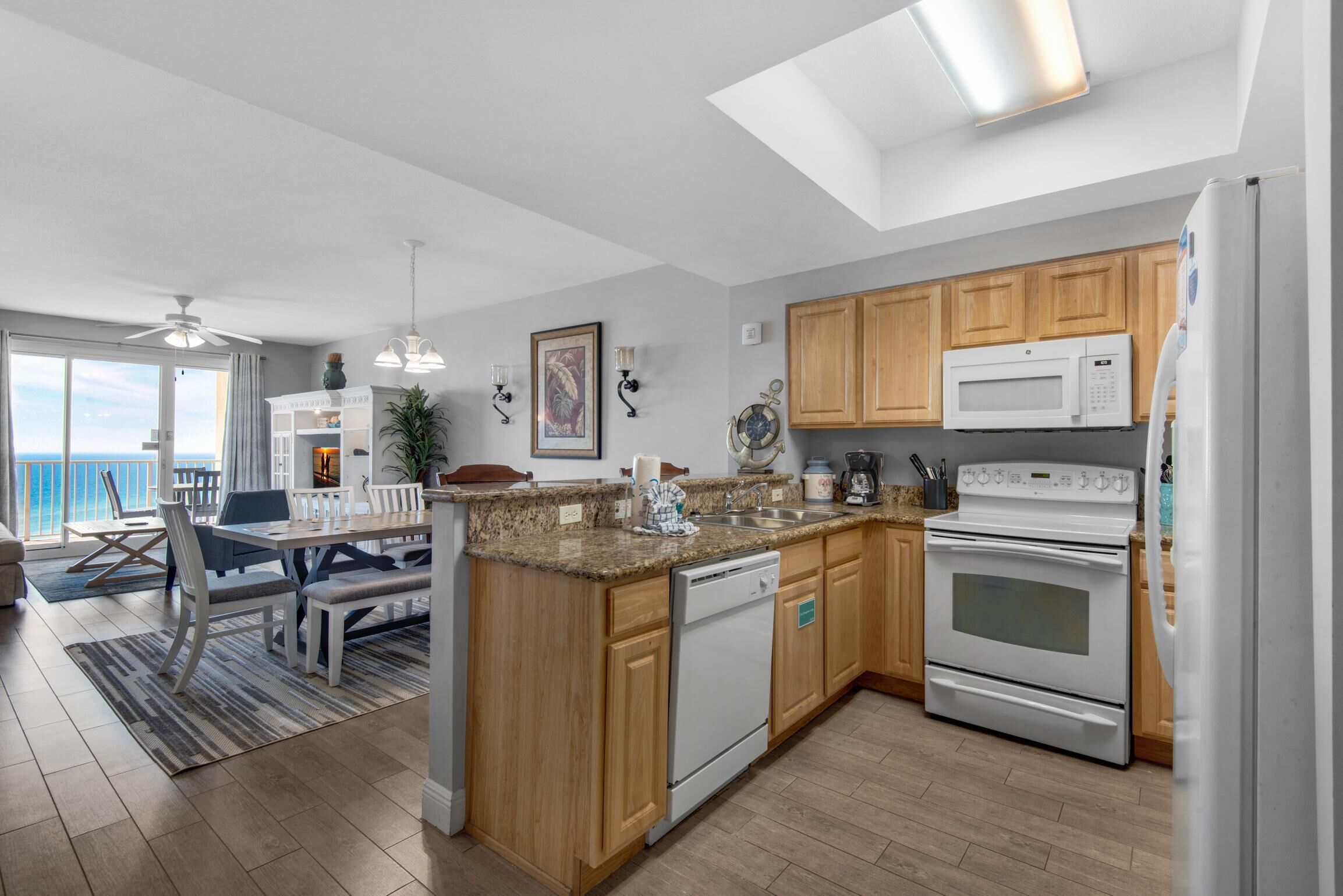 A modern kitchen with wooden cabinets, a built-in oven, a microwave, and a dishwasher.