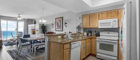 A modern kitchen with wooden cabinets, a built-in oven, a microwave, and a dishwasher.