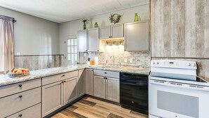 Une cuisine moderne avec des meubles de couleur gris clair, une cuisinière blanche et un lave-vaisselle.