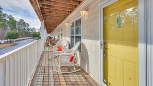 A wooden deck with rocking chairs and a yellow door. - Townhome w/ Outdoor Pool & White Lake Access! (Elizabethtown)