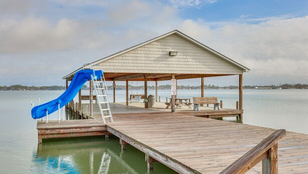 A wooden dock extending into a lake with a covered seating area and a blue slide. - Townhome w/ Outdoor Pool & White Lake Access! (Elizabethtown)