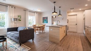 Eine moderne Küche mit Holzausstattung, einer zentralen Kochinsel und Pendelleuchten.