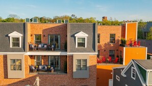 A multi-story building with a brick facade, balconies with outdoor seating, and a visible storefront labeled "HARVEST GALLERY". - Suite 302 - 470 Main (Wolfville)