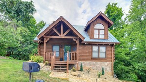 Eine Holzhütte mit Veranda, Steinuntergrund und blauem Dach.