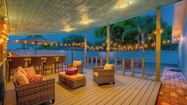 An outdoor patio area with wicker furniture, string lights, and a view of the surrounding landscape. - Hot Tub - Family - Dogs Allowed - Arcade Machine -MegaChess STR-A-25-00194 (St. Petersburg)