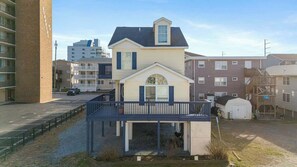 A two-story house with a balcony, a garage, and a small shed.