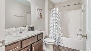 Une salle de bain avec un lavabo blanc, un miroir et des toilettes.