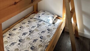 A bunk bed with a wooden frame and a patterned mattress.