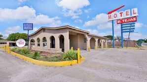 Un motel avec une enseigne indiquant « El Tejas Motel » et une grande enseigne « Motel ».