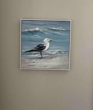 Een lijst met een schilderij van een zeemeeuw op het strand.