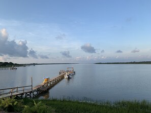 Een houten steiger die zich uitstrekt over kalm water, met een boot aan het einde aangemeerd.