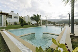 A swimming pool with a clear view of the surrounding buildings and mountains.